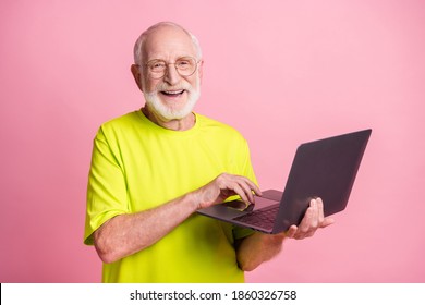 Portrait Of Funky Pensioner Typing Laptop Wear Spectacles Lime Color T-shirt Isolated On Pastel Pink Color Background