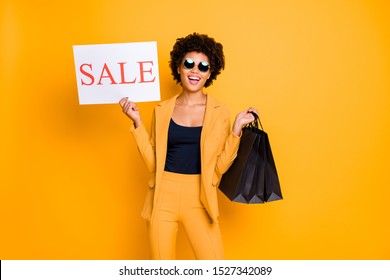 Portrait Of Funky Positive Cheerful Lady Hold Black Bags Enjoy Black Friday Sales On Leisure Time Want Shopping Wear Style Outfit Pants Trousers Isolated Over Yellow Color Background