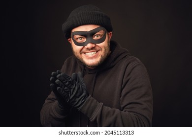 Portrait of funnu thief with mask over dark back