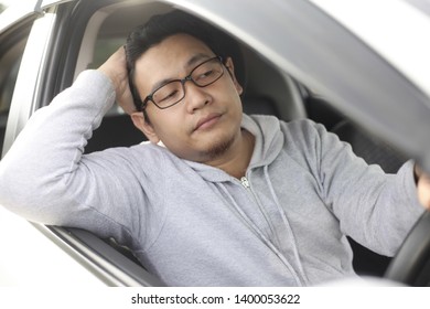 Portrait Of Funny Asian Male Driver Get Bored In His Car Trapped In Traffic Jam, Tired Lazy Facial Expression Gesture