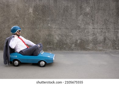 Portrait of funny businessman outdoor. Man driving retro pedal car. Back to work, start up and business idea concept