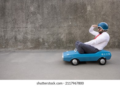 Portrait of funny businessman outdoor. Man driving retro pedal car. Back to work, start up and business idea concept
