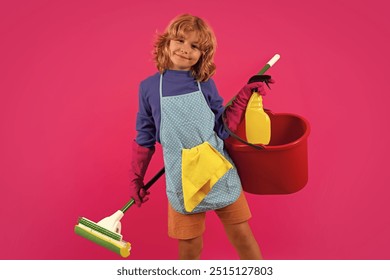 Portrait of funny child cleaning. Housekeeping and home cleaning concept. Child use duster and gloves for cleaning. Studio isolated pink background. - Powered by Shutterstock