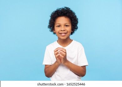 Portrait of funny devious little boy in T-shirt thinking over cunful idea and smiling at camera, disobedient sly child having tricky plans in mind. indoor studio shot isolated on blue background - Powered by Shutterstock