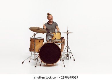 Portrait Of Funny Emotive Man Playing Drums, Performing Isolated Over White Background. Bass, Rock Music. Concept Of Live Music, Performance, Retro Style, Creativity, Artistic Lifestyle
