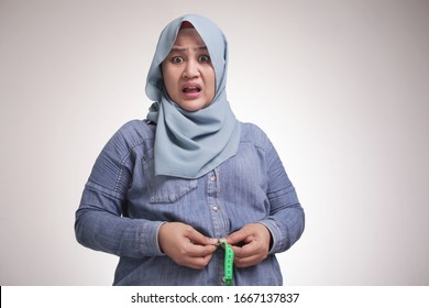 Portrait Of Funny Fat Asian Muslim Woman Shocked Worried To See Her Big Belly, Measuring Waist, Obese Concept