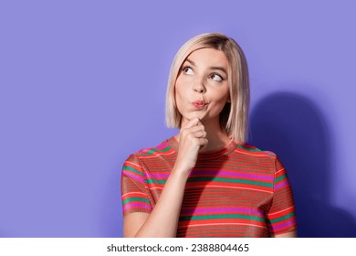 Portrait of funny girl touch chin looking interested empty space during deep thinking pouted lips isolated on purple color background