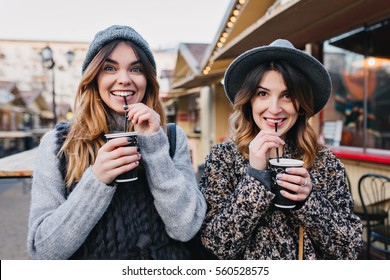 Portrait funny joyful attractive young women with drinks having fun on sunny street in city, smiling, lovely moments, best friends, expressing true positive emotions