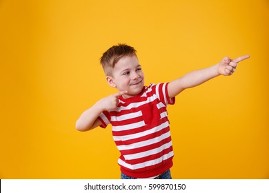 Portrait Of A Funny Little Kid Pointing Fingers Away Isolated Over Orange Background