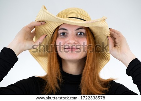 Portrait of funny redhead woman in bag yellow straw hat.