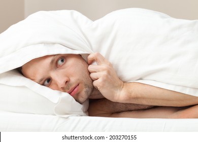 Portrait Of Funny Scared Young Caucasian Man In Bed