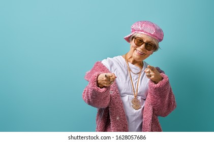Portrait of funny senior woman on color background. Empty space for text.                               
