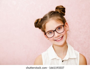 Portrait Of Funny Smiling Little Girl Child Wearing Glasses Isolated On A Pink Background