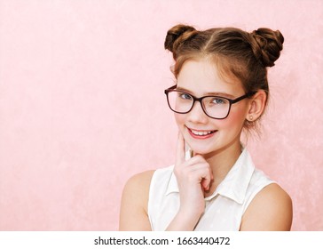 Portrait Of Funny Smiling Little Girl Child Wearing Glasses Isolated On A Pink Background