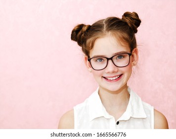 Portrait Of Funny Smiling Little Girl Child Wearing Glasses Isolated On A Pink Background