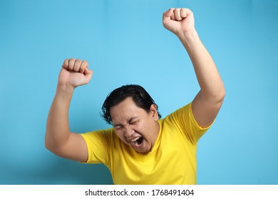 Portrait of a funny young Asian man smiling and dancing happily, joyful expressing celebrating good news victory winning success gesture - Shutterstock ID 1768491404