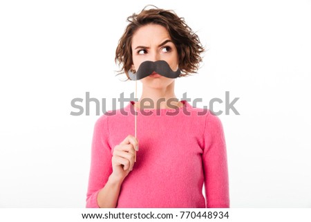 Portrait of a funny young girl holding paper moustaches at her face isolated over white background