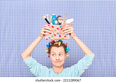 Portrait Of Funny Young Woman With Colorful Hair Curlers On Head, Holding Makeup Bag With Beauty Treatment Accessories And Cosmetics, Making Goofy Face, Fooling Arounds Over Shower Curtain Background