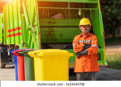 Portrait of garbage collector with truck loading waste and trash bin.