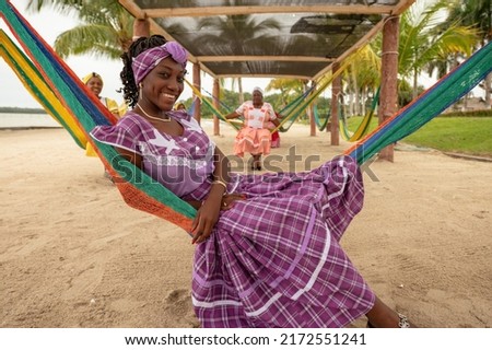 Portrait of a Garifuna girl sitting in a hammock wearing a typical dress from Livingston Izabal.