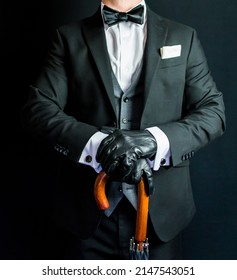 Portrait of Gentleman in Dark Suit and Leather Gloves Holding Umbrella. Vintage Style and Retro Fashion.