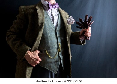 Portrait of Gentleman in Tweed Suit Holding Leather Gloves. Concept of Classic and Eccentric English Gentleman. Vintage Style and Retro Fashion.