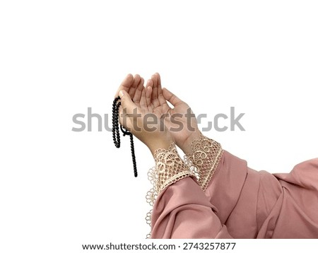 A portrait of a gesture of praying devoutly to Allah with hands raised and holding prayer beads, isolated on a white background. The concept of Islamic life. The concept of Eid al-Fitr and Ramadan