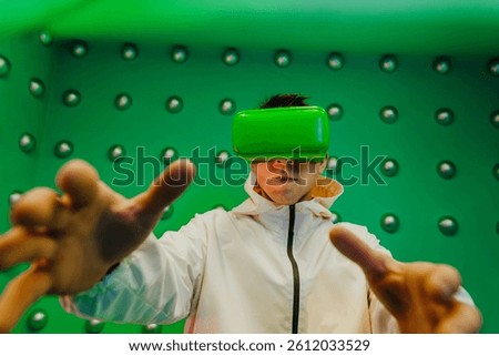 Portrait of gesturing man using virtual reality glasses standing over green futuristic background
