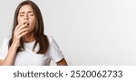 Portrait of girl with allergy sneezing, cover mouth with hand. Sick woman standing over white background.