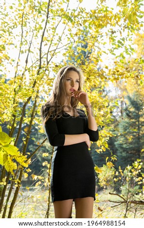 Portrait of a girl in an autumn park against a background of yellow foliage. Blurred background. Selective focus.