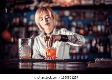 Portrait of girl bartender demonstrates the process of making a cocktail