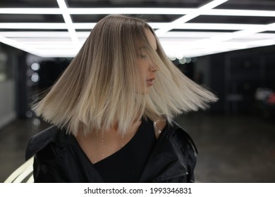 Portrait Of A Girl With Bright Blond Hair That Scatters From The Movement. Fashion Photography Of Urban Style. High Quality Photo