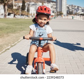 Portrait, girl child and cycling on sidewalk, learning to ride bike or healthy childhood development. Happy kid riding tricycle with helmet, safety and outdoor fun in summer, sunshine and Atlanta USA - Powered by Shutterstock