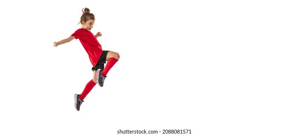 Portrait Of Girl, Child, Football Player In Uniform Training, Kicking Ball With Knee Isolated Over White Background. Concept Of Action, Team Sport Game, Energy, Vitality. Copy Space For Ad.