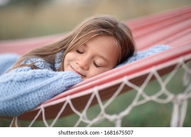 Portrait Of A Girl , A Child Lying On Her Stomach In A Hammock, Hands Under Her Head, Eyes Closed, Smiling While Hiking