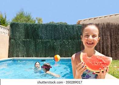 Portrait of girl child smiling eating a slice of watermelon by a swimming pool with joyful children playing in a home garden on a sunny holiday, outdoors. Active kids lifestyle exterior vacation.