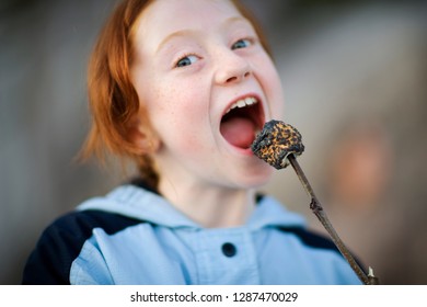 Portrait Of A Girl Eating A Burnt Marshmallow.