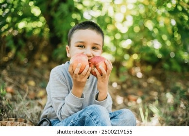 portrait of girl eating red organic apple outdoor. Harvest Concept. Child picking apples on farm in autumn. Children and Ecology. Healthy nutrition Garden Food. Boy holding in front of his face apple - Powered by Shutterstock