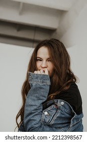 Portrait Of A Girl With Flirting Look In Denim Jacket. Studio Portraits Of A Girl With Variety Of Facial Expressions And Poses.