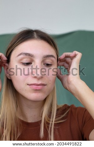Portrait girl with hands near the face partially green background eyes are down