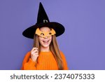 Portrait of girl hiding face behind bat mask witchcraft costume look copy space for decorations shop isolated on violet color background