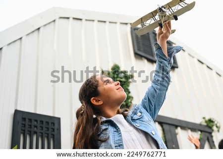 Portrait of girl holding plane toy and smiling to camera, Child with activities at home, Happy lady portrait