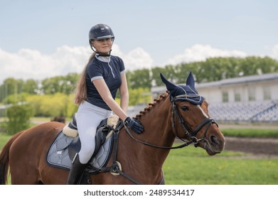 Portrait of a girl jockey riding a horse.  - Powered by Shutterstock