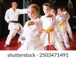 Portrait of girl kid training karate movements in sport class in school