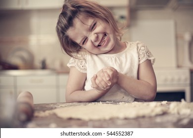 Portrait of girl in kitchen baking cookies . Looking at camera.