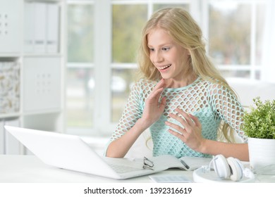 Portrait of girl with laptop while sitting at desk and studying - Shutterstock ID 1392316619