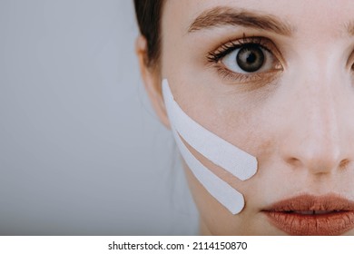 Portrait of a girl with lifting tape on her face. Kinesio taping.