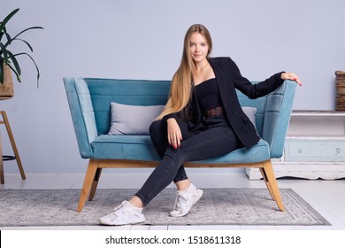 Portrait Of Girl With Long Straight Hair, Healthy Skin And No Makeup Sitting On Couch At Home