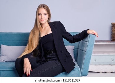 Portrait Of Girl With Long Straight Hair, Healthy Skin And No Makeup Sitting On Couch At Home