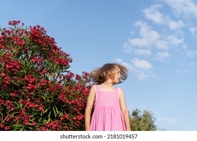 Portrait Of A Girl Near A Flowering Oleander Bush.